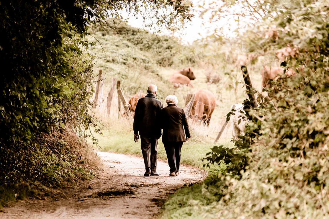 elderly couple walking down country road